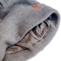 Close-up of a gray beanie with a brown label, showing interior lining designed for RF signal blocking.