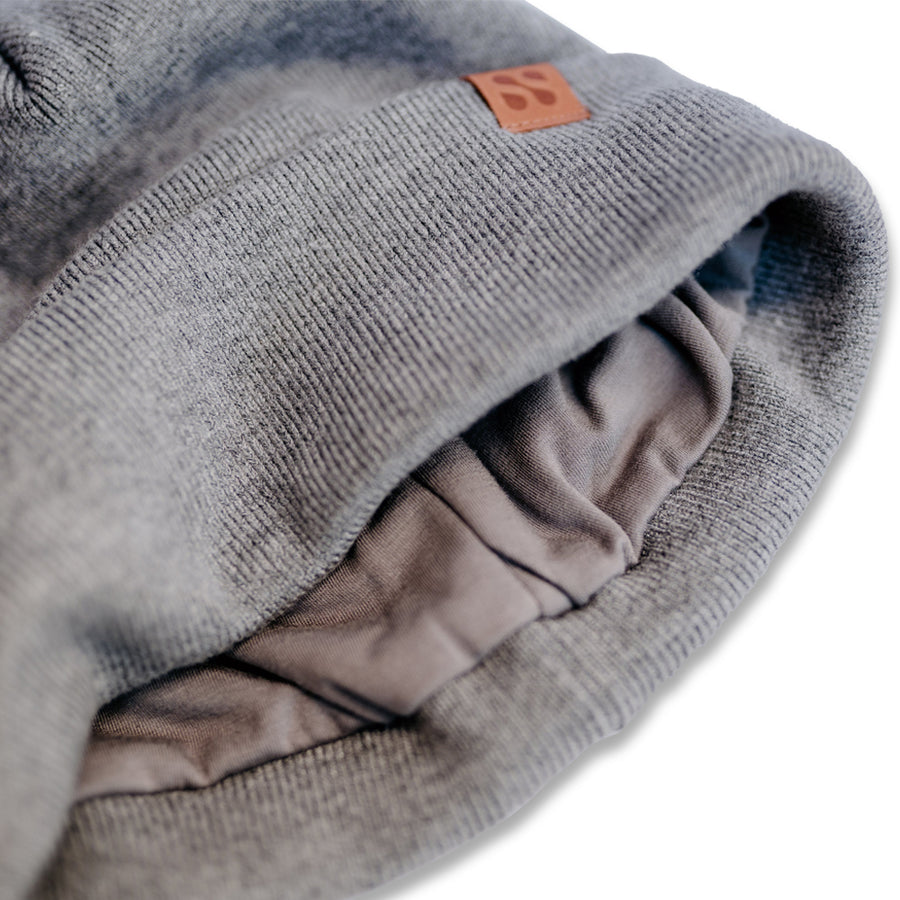 Close-up of a gray beanie with a brown label, showing interior lining designed for RF signal blocking.