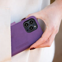 Purple SafeSleeve phone case with protective design for iPhone 14 series, held in a person's hand.